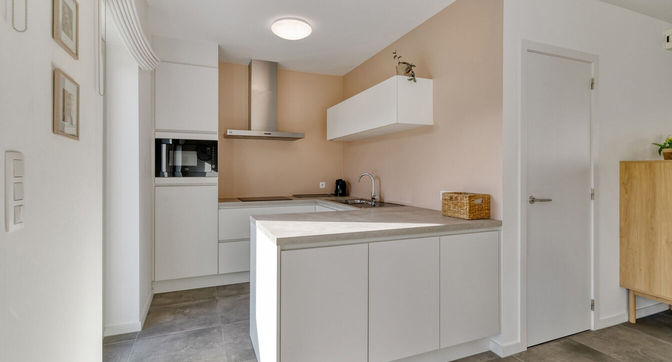 Deze stijlvolle en energiezuinige woning combineert hedendaags wooncomfort met een praktische indeling en een aangename buitenruimte.
Bij het binnenkomen verwelkomt de inkomhal je met een apart gastentoilet. Vervolgens kom je in de ruime leefruimte met o