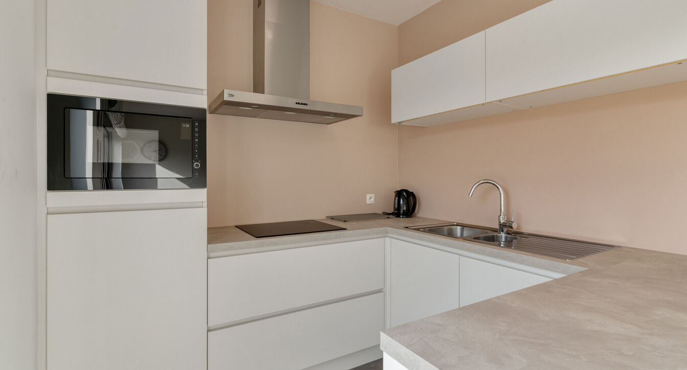 Deze stijlvolle en energiezuinige woning combineert hedendaags wooncomfort met een praktische indeling en een aangename buitenruimte.
Bij het binnenkomen verwelkomt de inkomhal je met een apart gastentoilet. Vervolgens kom je in de ruime leefruimte met o