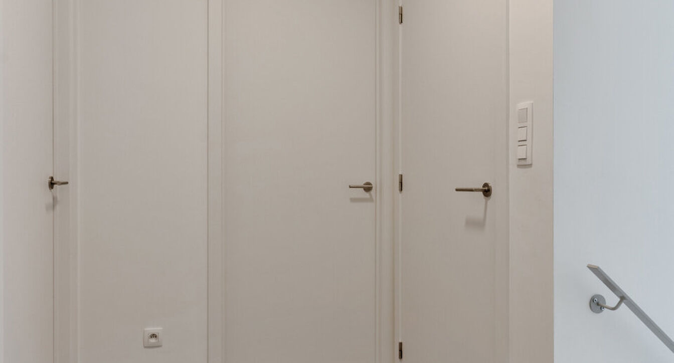 Deze stijlvolle en energiezuinige woning combineert hedendaags wooncomfort met een praktische indeling en een aangename buitenruimte.
Bij het binnenkomen verwelkomt de inkomhal je met een apart gastentoilet. Vervolgens kom je in de ruime leefruimte met o